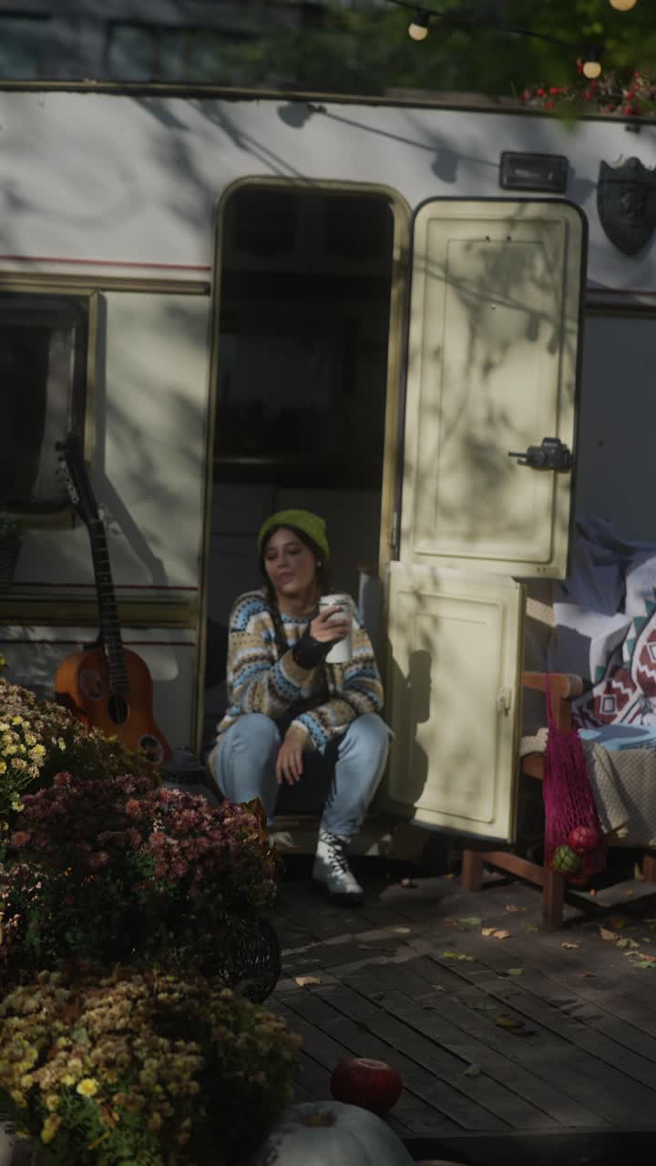 Donna che si rilassa in un camper in una soleggiata giornata autunnale
