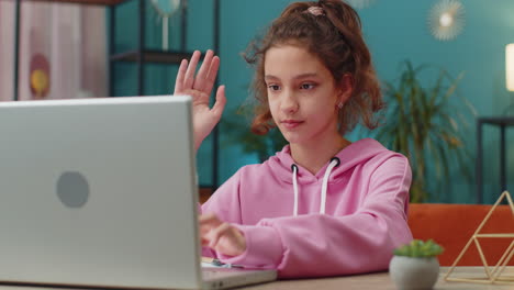 preteen school girl using laptop for online lesson doing homework distance learning education
