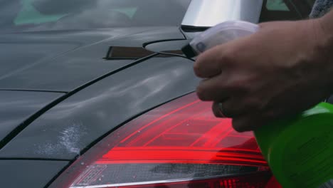 polishing car with spray wax and mitt
