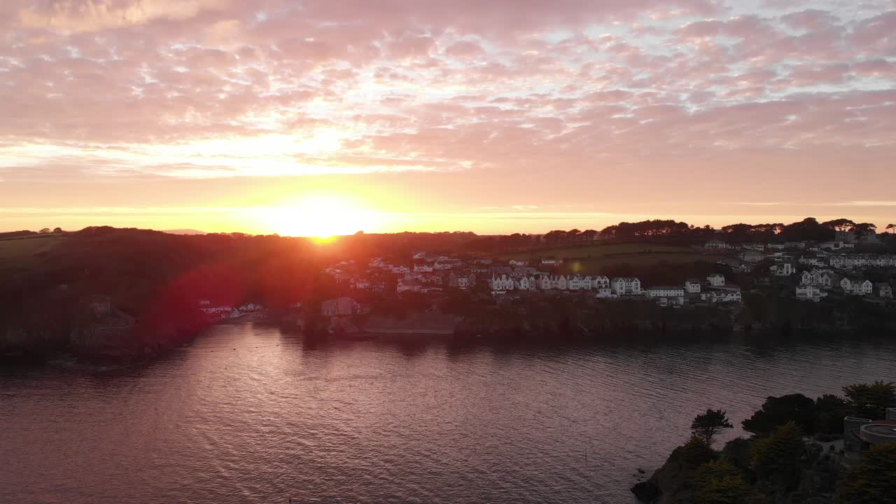 cativante foto de drone lenta do porto de fowey ao pôr do sol, revelando beleza serena e águas calmas