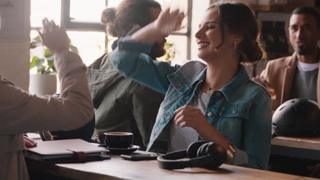beautiful-woman-chatting-with-friend-in-cafe-laughing-at-funny-conversation-high-five-enjoying-hanging-out-in-busy-restaurant
