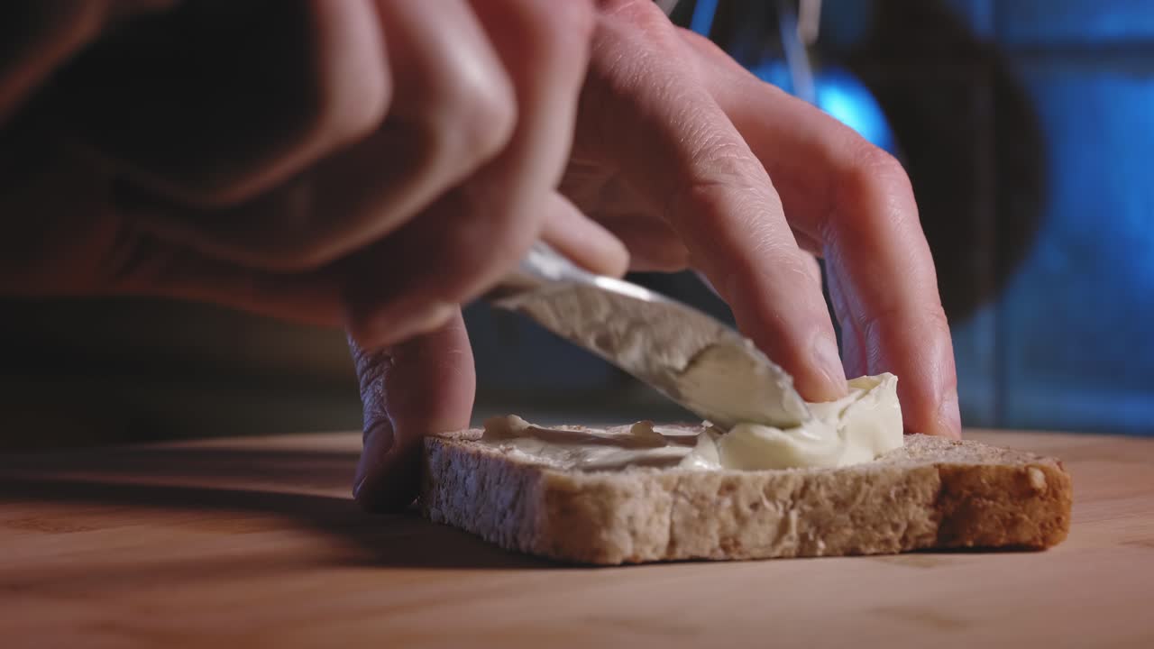 Hands Spread Cheese On A Slice Of Whole Grain Bread