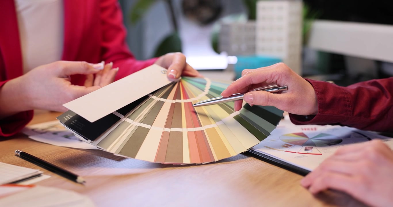Interior designer donna mostra una mazzetta colori al cliente