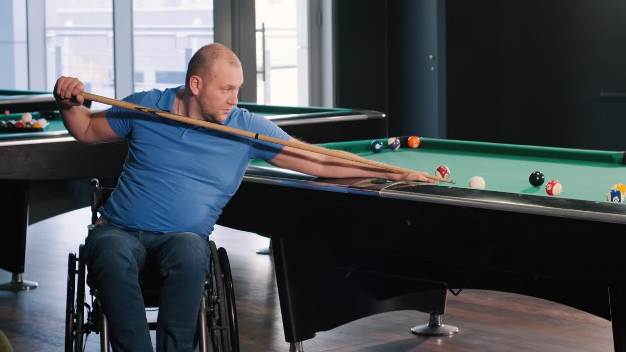 Volwassen mannen met een handicap in een rolstoel spelen biljart in de club