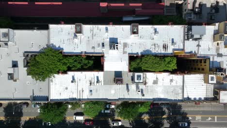Top-down-aerial-truck-shot-above-houses-and-apartments-in-New-York-City-with-trees-in-common-court-yard-areas
