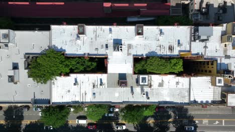 top down aerial truck shot above houses and apartments in new york city with trees in common court yard areas