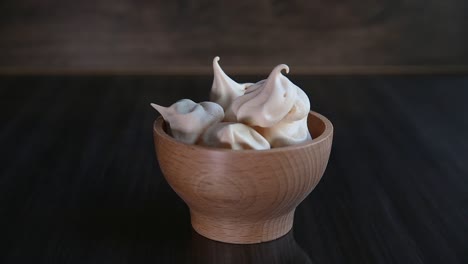 Child's-hand-taking-homemade-meringue-from-wooden-bowl