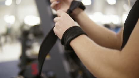 young attractive female bodybuilder ties fitness straps around barbellpreparing to train. fitness and workout. healthcare.