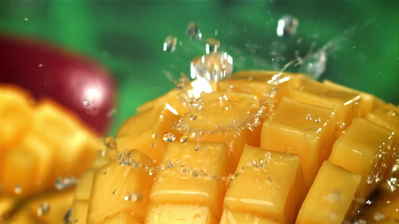 Acqua rinfrescante che schizza su cubetti di mango succosi