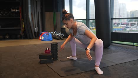 mujer estirándose en el gimnasio