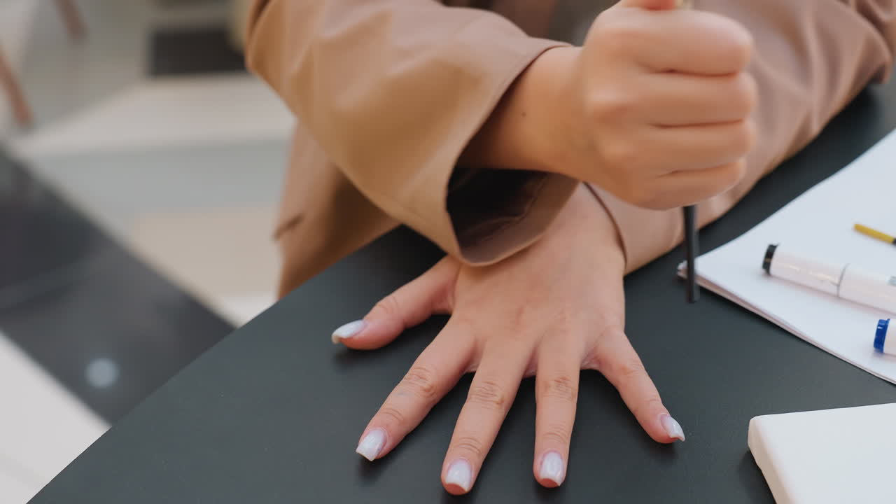 Mujer joven con actitud segura, elegante señora golpeando un bolígrafo en el escritorio durante una visita al centro comercial, mujer joven blanca con blazer mostrando una acción de escritura asertiva en un entorno de centro comercial