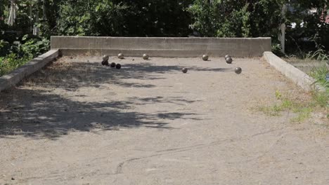 Mano-De-Hombre-Lanzando-Bochas-En-El-Campo-De-Arena