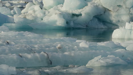 Glacier-Lagoon,-Jökulsárlón,-Iceland,-with-icebergs-and-flowing-icy-blue-water