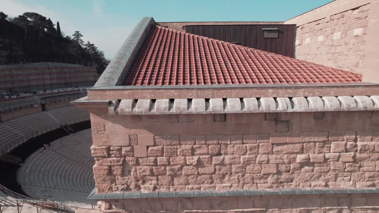 una toma aérea de turistas explorando el interior del teatro naranja