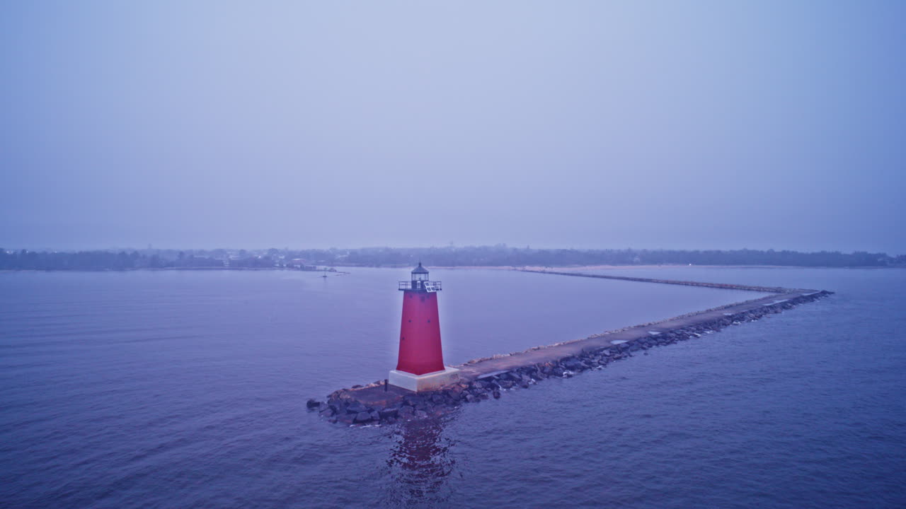 Drone shot panning around lighthouse on the edge of Lake Michigan