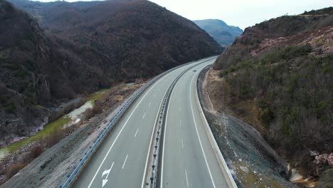 volando sobre la carretera donde los autos y autobuses pasan por el hermoso valle montañoso en el norte de albania