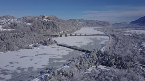 4k aerial video view of alpine snowy valley forest and frozen river with bridges overflight - drone collection stock video