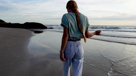 Schöne-Frau,-Die-Beim-Spaziergang-Am-Strand-Lange-Haare-Anpasst,-Rückansicht