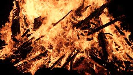 una gran hoguera arde por la noche en cámara lenta sobre un fondo negro en la naturaleza