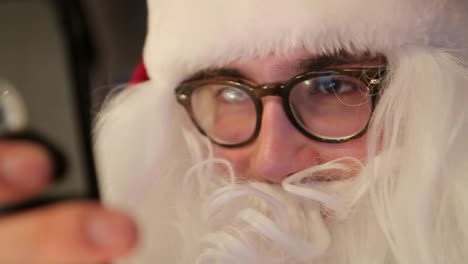 old santa claus and modern digital technologies tired of social networks old santa claus and modern digital technologies tired of social networks surprised by the letter and wishes from children christmas decoration with new year tree garlands and holiday lights