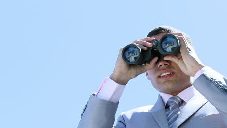 young businessman looking through binoculars