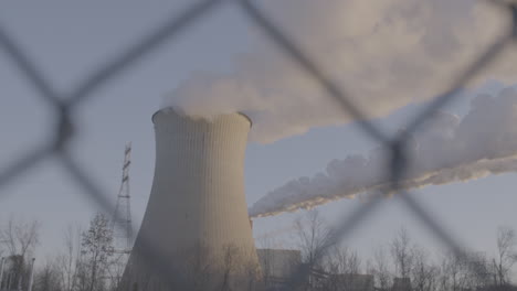 smoke stack from behind a fence