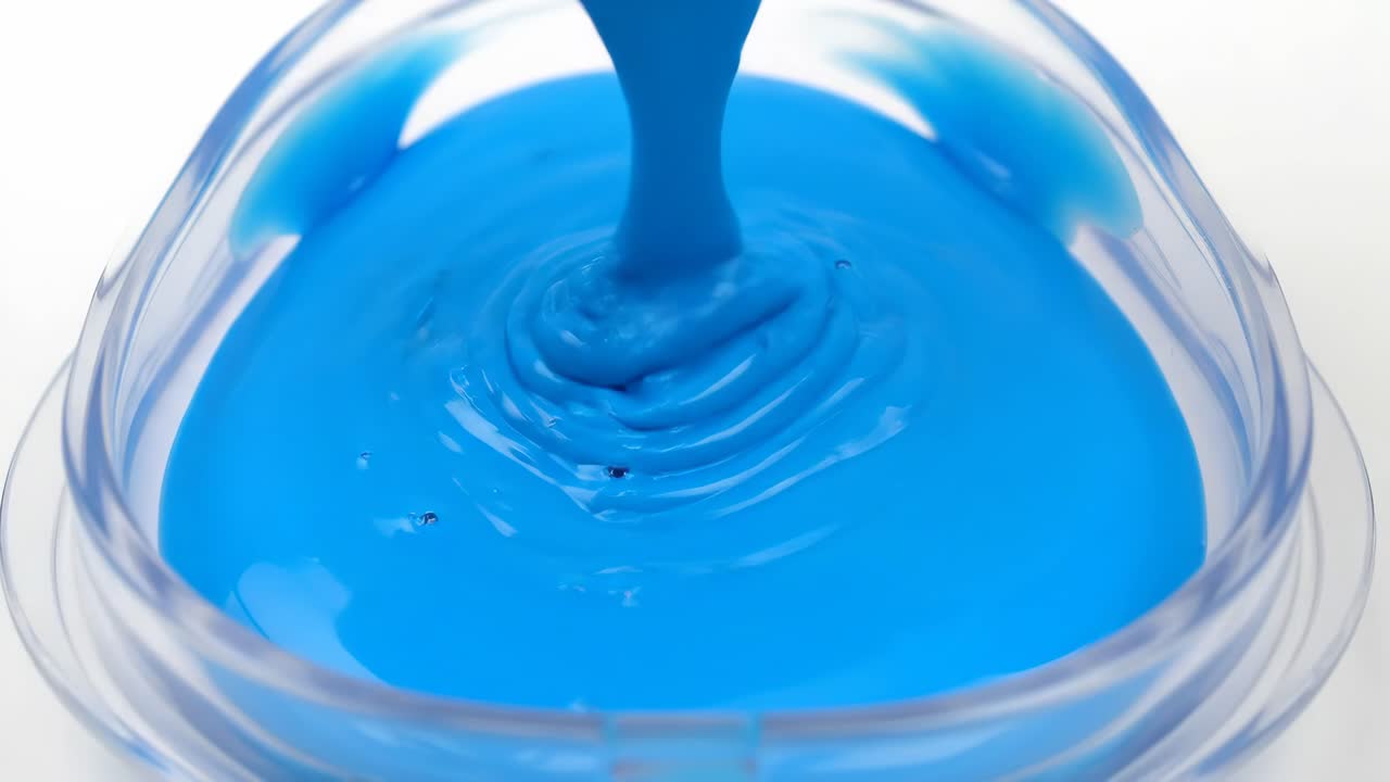 Blue liquid being poured into a container