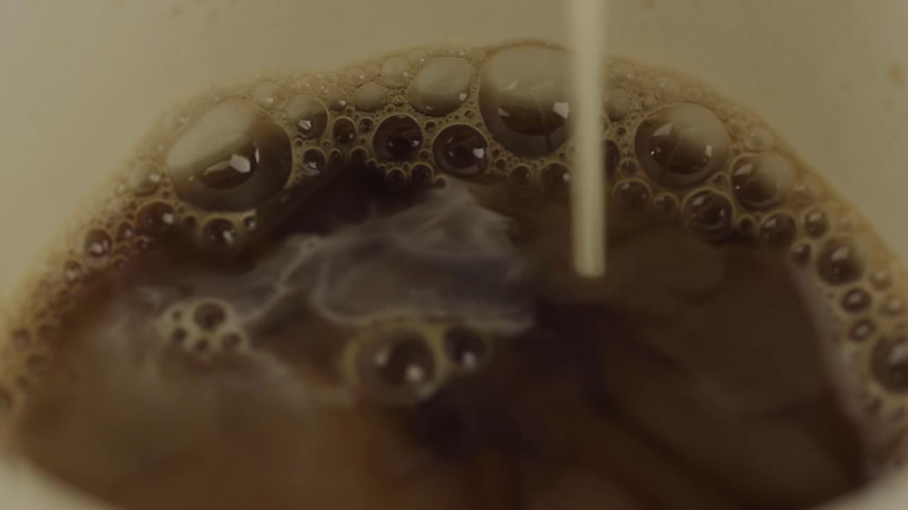 Pouring milk into coffee macro shot