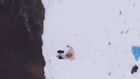 Plan-view-of-a-woman-in-underwater-entering-icy-lakewater-for-her-routine-plunge