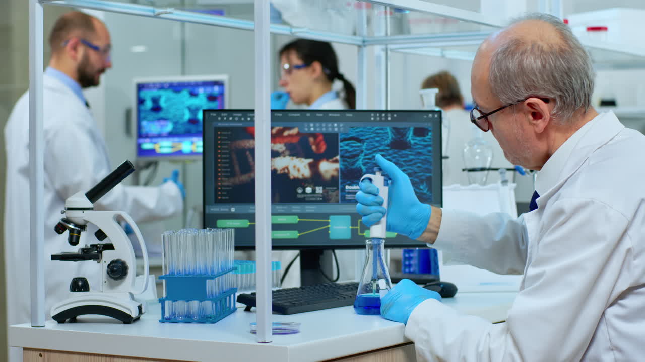 Microchemist putting liquid in test tube at laboratory using micropipette