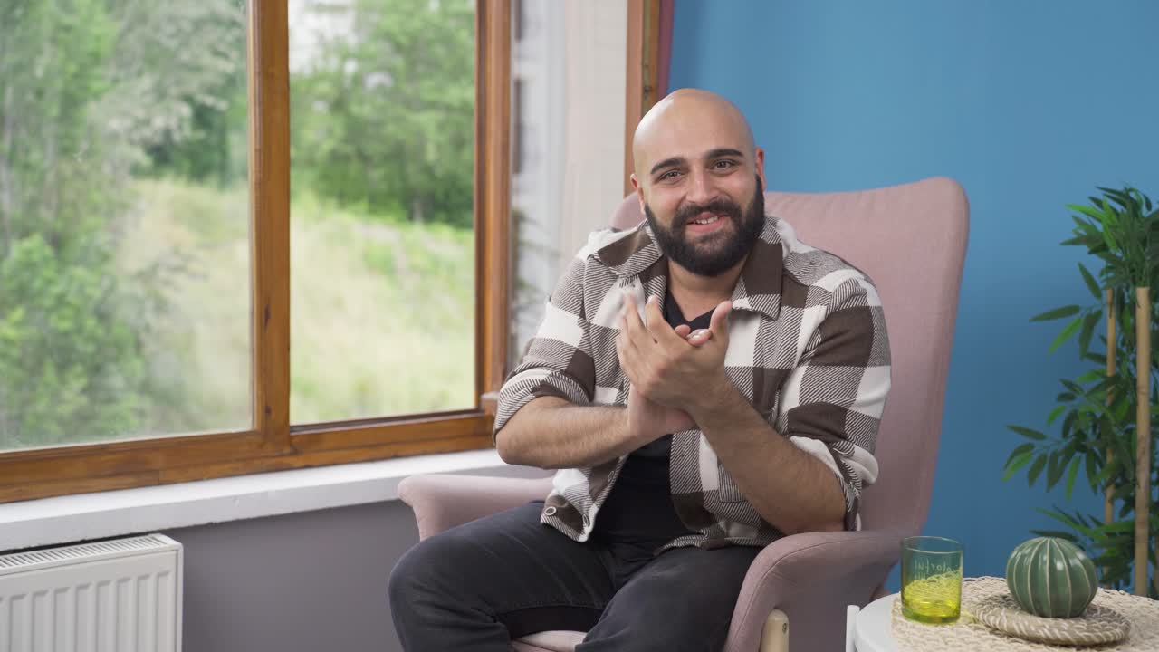 hombre dando mensaje de felicitación a la cámara aplaudiendo.