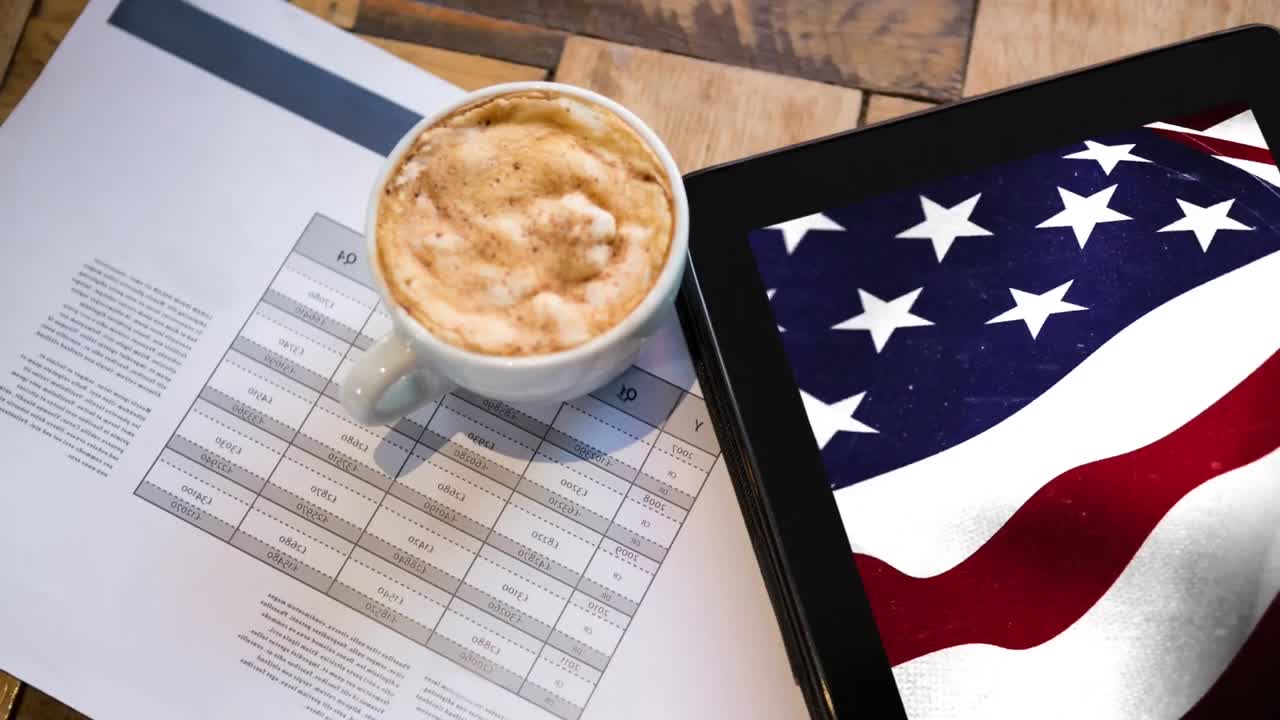 Tablet che mostra un video della bandiera americana con caffè sulla scrivania
