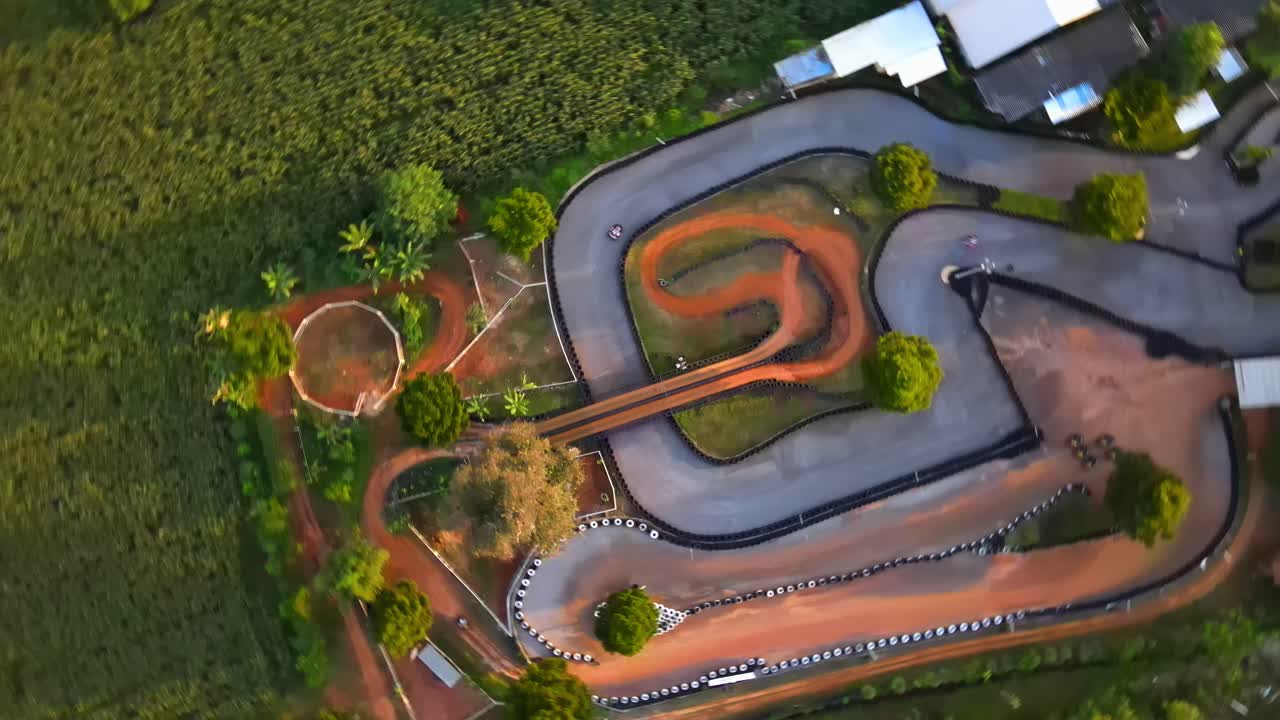 4k 무인 항공기는 일몰 트랙에서 카트 경주를 따라 우회전합니다.