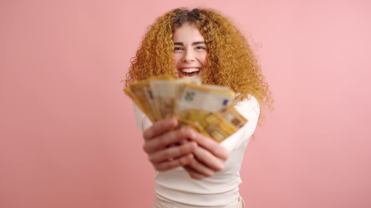 Donna entusiasta che celebra il successo finanziario con denaro contante