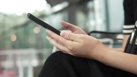 woman's hands and finger touching scroll page app on mobile phone, browsing pictures in phone's gallery - side view, close-up