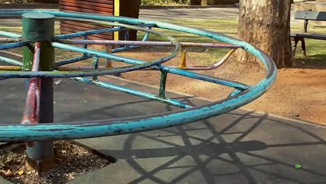 Merry go round spinning into frame at a park