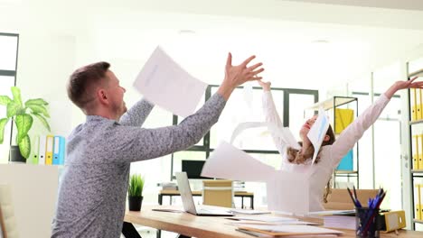 People celebrating in an office throwing papers