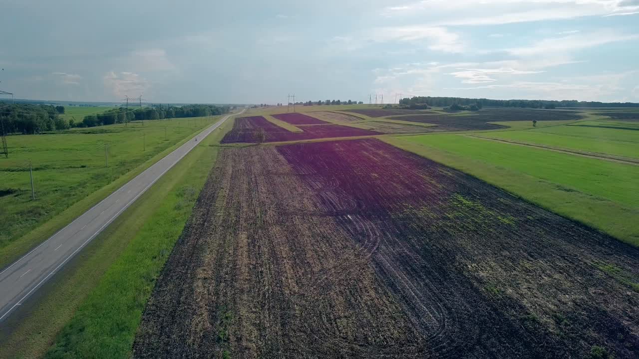 luftansicht braunes gepflügeltes feld in der nähe der straße mit motorrad