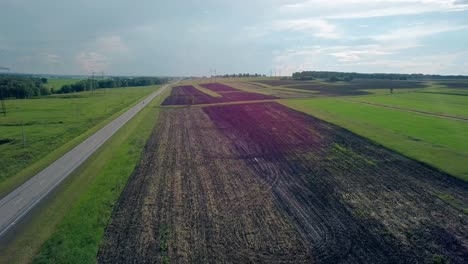 aerial-view-brown-plowed-field-near-road-with-motorcycle