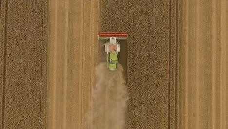 harvest drone fly upwards away from combine harvester over crop field