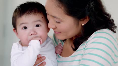 Mother kissing her baby on the cheek