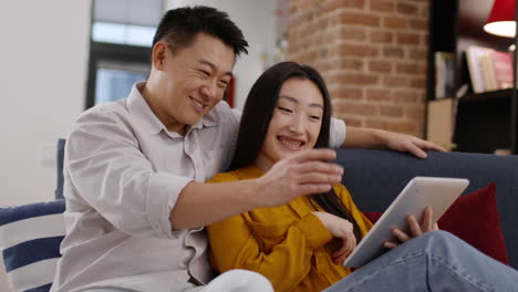 happy couple using tablet at home