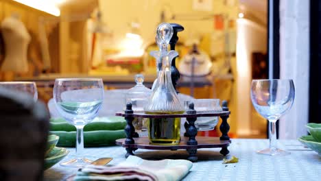 establishing-shot-of-a-set-table-with-crystal-glasses-and-oil-decanters