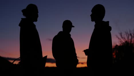 group of young men standing in magical blue hour lighting, smoking cigarettes and chatting