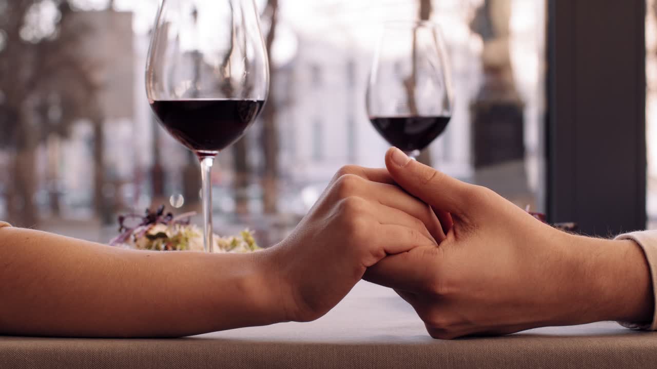Coppia che si tiene per mano al ristorante
