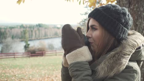 adult girl is drinking hot beverage in cold autumn day feeling good