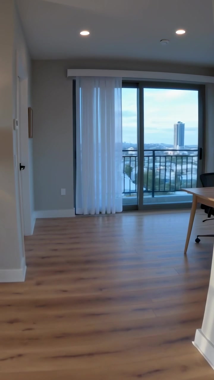 Vertical video: Tapping smartphone, filmer starting camera moving through home toward balcony view