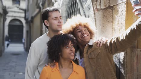 group of cheerful diverse friends taking selfie in street