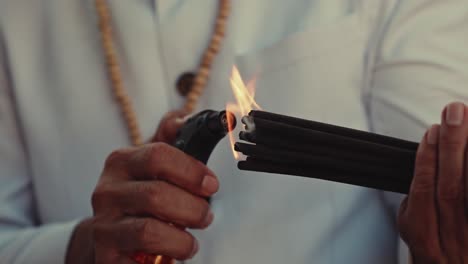 priest lighting up incense for ritual procedure, close up