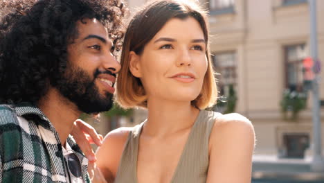 una feliz pareja interracial riendo al aire libre